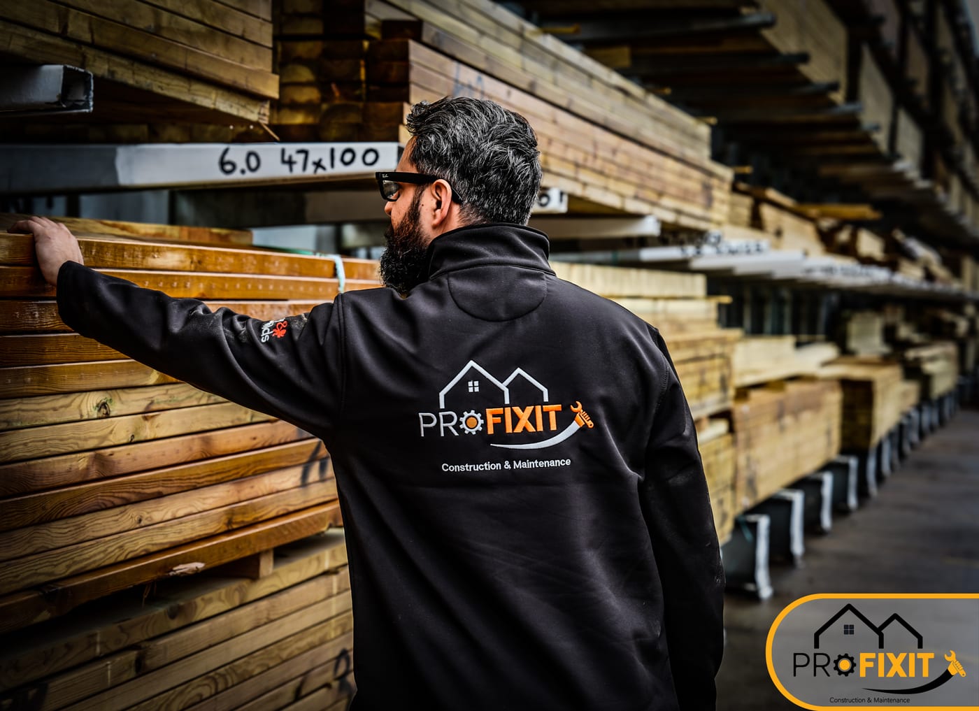 A worker checking marked timber lengths at a builders merchant.